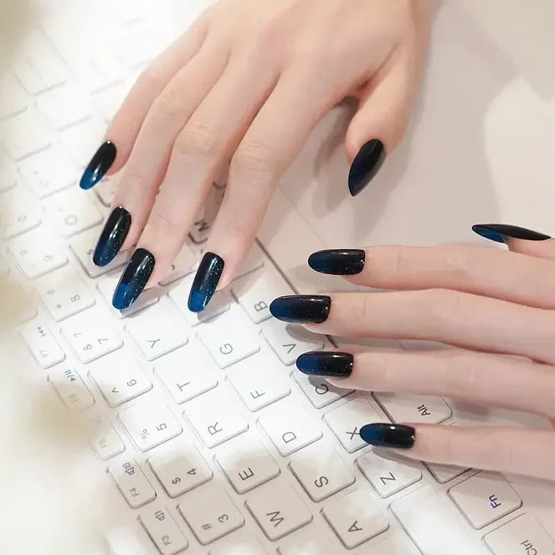 Emerald Twinkle dark green glitter manicure typing on a keyboard