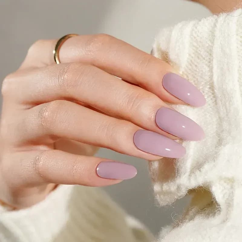 Lavender Love dusty lavender pink gel nails on almond nails against a cream knit
