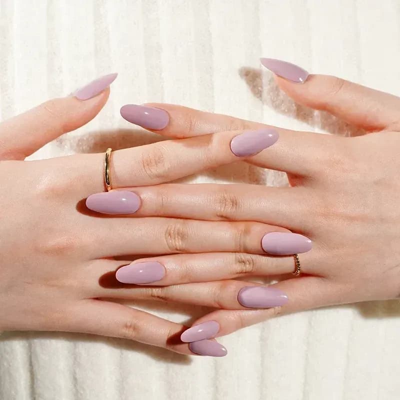 Lavender Love dusty lavender pink gel nails shown on crossed hands with gold rings