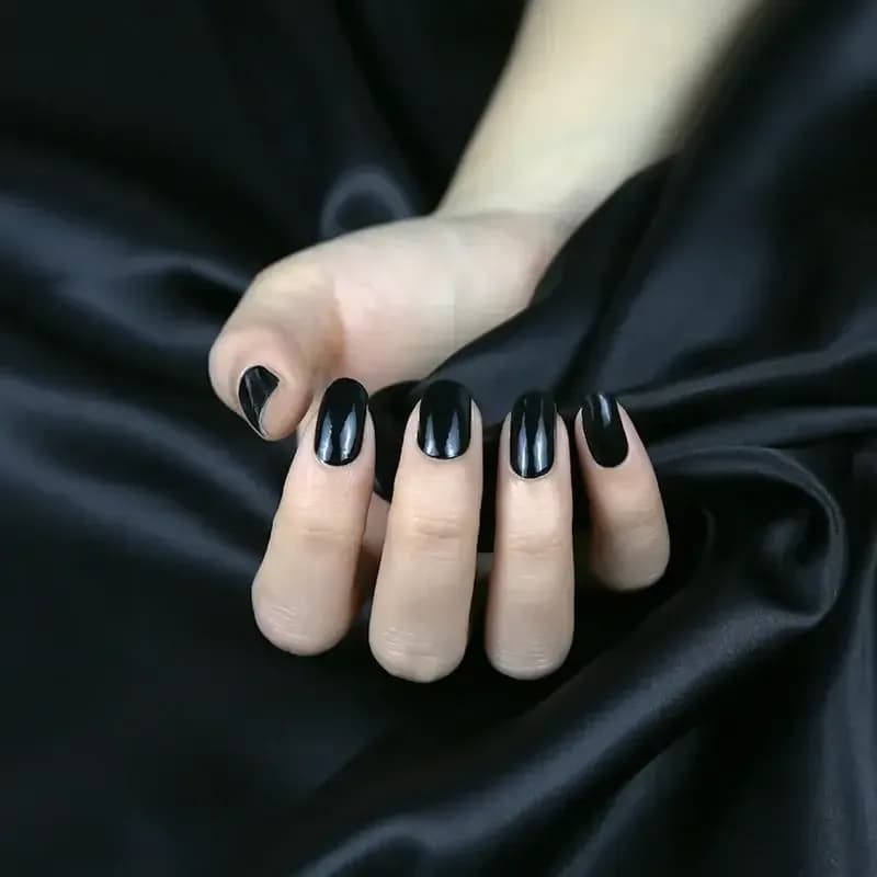 Noir Nights glossy black gel nails against black satin