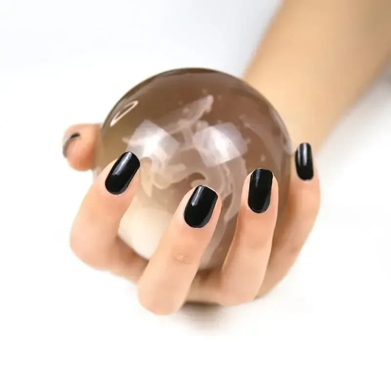 Noir Nights black gel nails holding a crystal ball