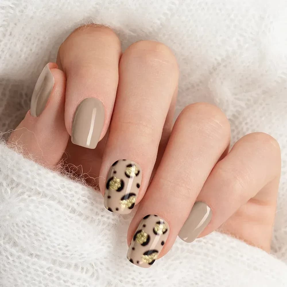 Nude Safari taupe gel nails with gold glitter leopard print accent nails, close up