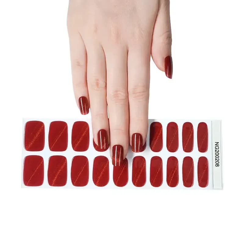 Ruby Slippers glittering red gel nail strips, the full 20-strip sheet under a manicured hand