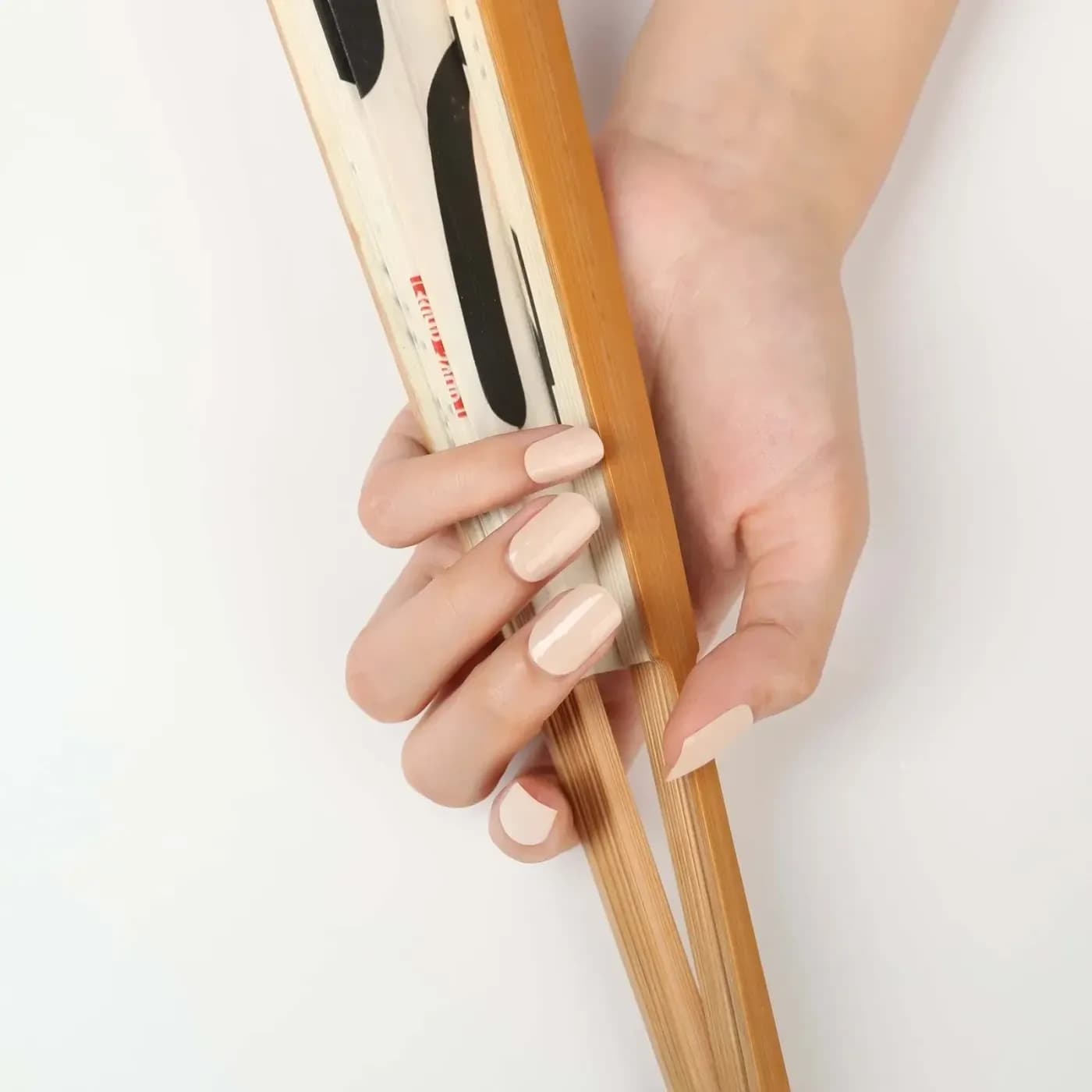 Think Pink pale blush pink gel nails holding a folded book fan