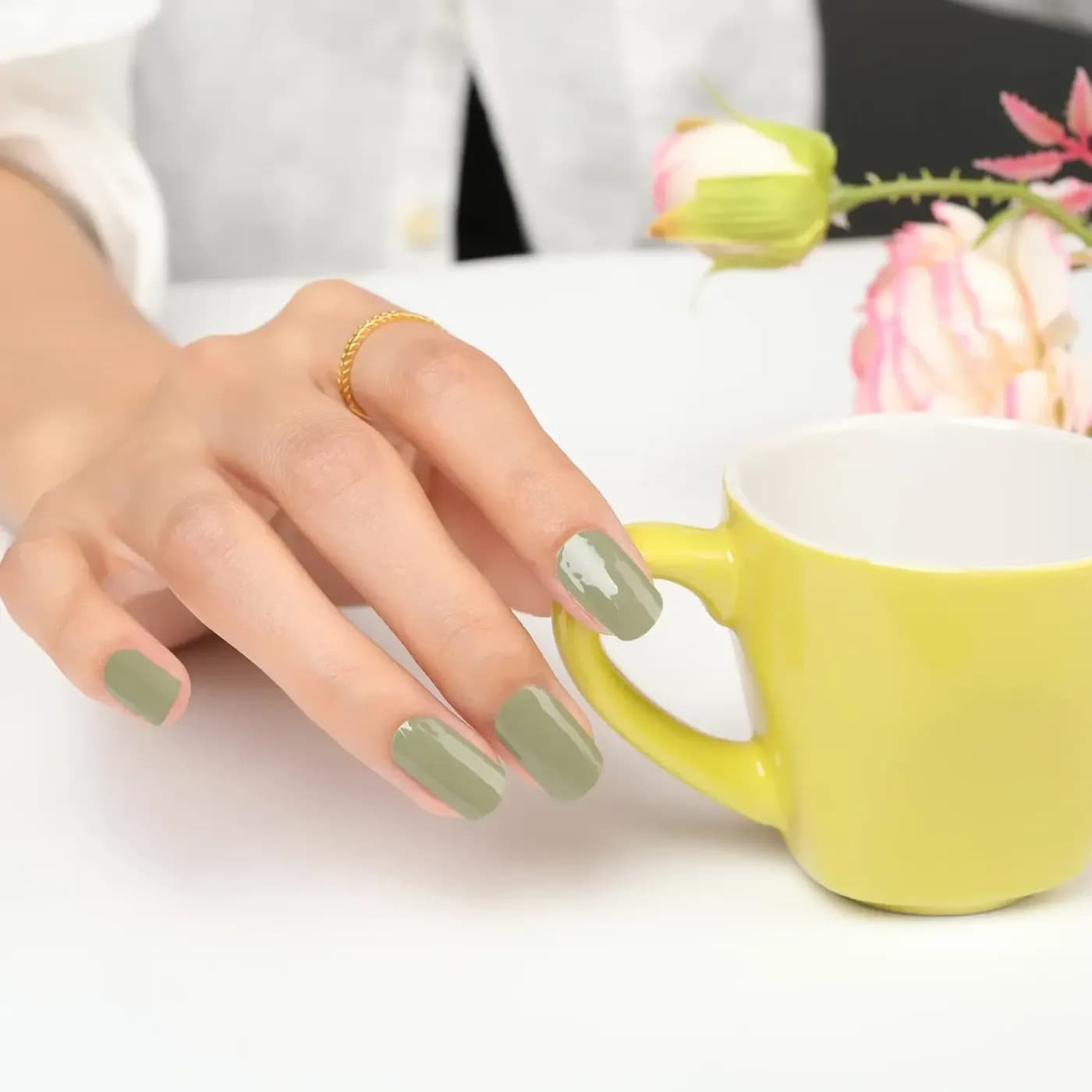 Urban Jungle sage green manicure holding a yellow mug