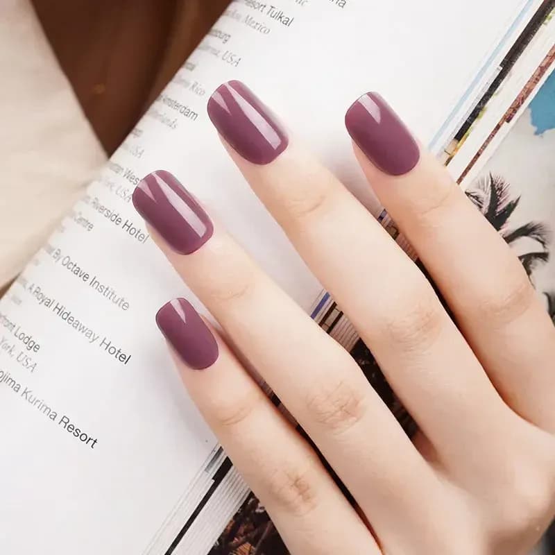 Vintage Rose dusty mauve gel nails, close up over a travel magazine