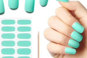 Hand with turquoise gel nail strips and matching set laid out for application
