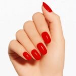 Hand showing semi-cured gel nail strips in Velvet Rouge