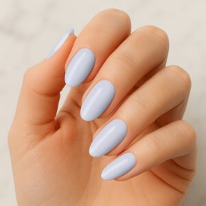 Hand with almond-shaped nails wearing glossy light blue semi-cured gel nail strips – pastel manicure for a fresh, summery at-home nail look