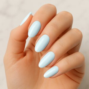 Hand with almond-shaped nails wearing glossy light blue semi-cured gel nail strips from Velvora – breezy, coastal-inspired manicure for UK beauty lovers wanting flawless nails at home.