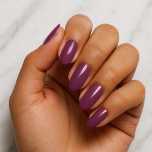 Hand with almond-shaped nails wearing glossy mauve purple semi-cured gel nail strips from Velvora – romantic, vintage-inspired manicure for UK beauty lovers wanting chic, salon-quality nails at home.