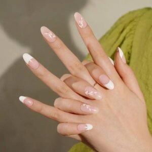 Two hands wearing Velvora’s French Tip Bloom semi-cured gel nail strips with white French tips and botanical gold accents