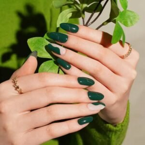 Jungle Vibes semi-cured gel nail wraps shown outdoors with leaf props – Velvora UK emerald green nails with curved nude detail