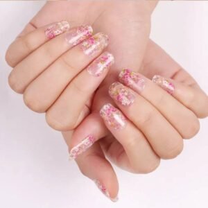 Overlapping hands with Velvora Blooming flower-pattern semi-cured gel nail strips on pink floral fabric.