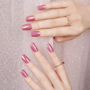Single hand wearing Velvora Holographic Pink gel strips with tulle and bokeh lights behind.