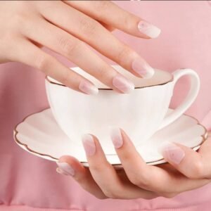 Velvora modern French tip semi-cured gel nail strips on natural nails while holding teacup – soft pink ombré