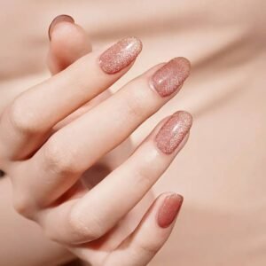 Peachy Ombre semi-cured gel nail strips on manicured hand, shimmering peach-to-nude ombré finish