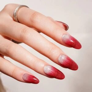 Close-up of Velvora Red Ombre nails: ruby-red fading to silvery pearl at the cuticle.