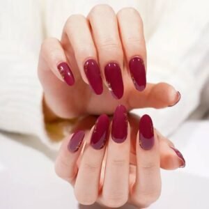 Both hands with Velvora Royal Rose wine-red gold-foil nail wraps.