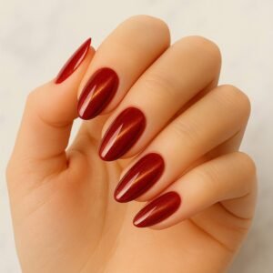 Velvora Ruby Slippers semi-cured gel nail strips in rich ruby red with golden shimmer on almond-shaped nails, product photo for UK customers