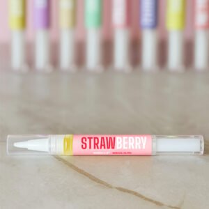 Velvora Strawberry Cuticle Oil Pen on marble with blurred rainbow pens behind – ideal gel manicure partner.