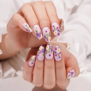Both hands with Velvora Violet Blooms floral gel nail wraps against a white blouse.