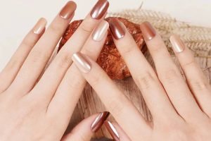 Hands with metallic nude gel nail strips, styled for a natural and damage-free manicure