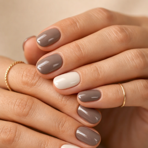 Earth tone nails trend for 2026 with glossy taupe and milky white manicure